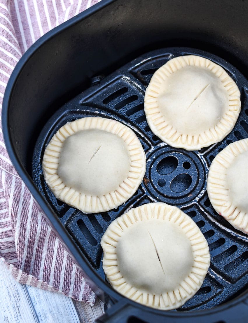 homemade cherry hand pies in the basket of an air fryer