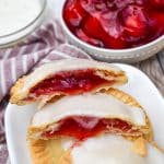 a pile of air fried glazed cherry hand pies on a wooden table
