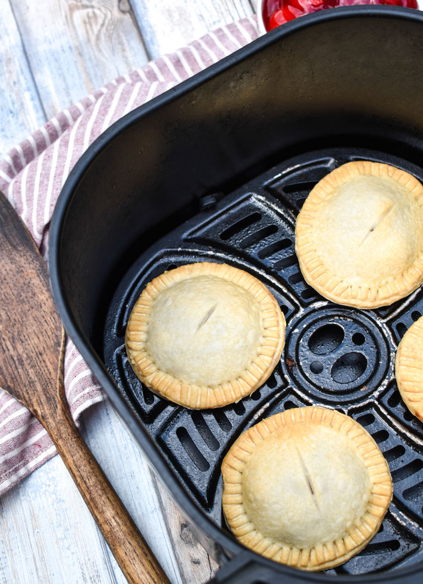 homemade cherry hand pies in the basket of an air fryer