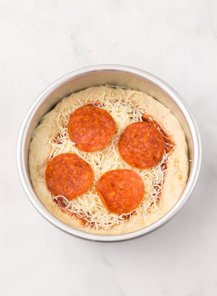 a homemade personal pan pizza in a small circular metal baking pan