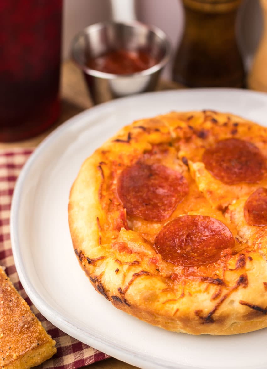 a close up of a copycat pizza hut personal pan pizza on a white plate