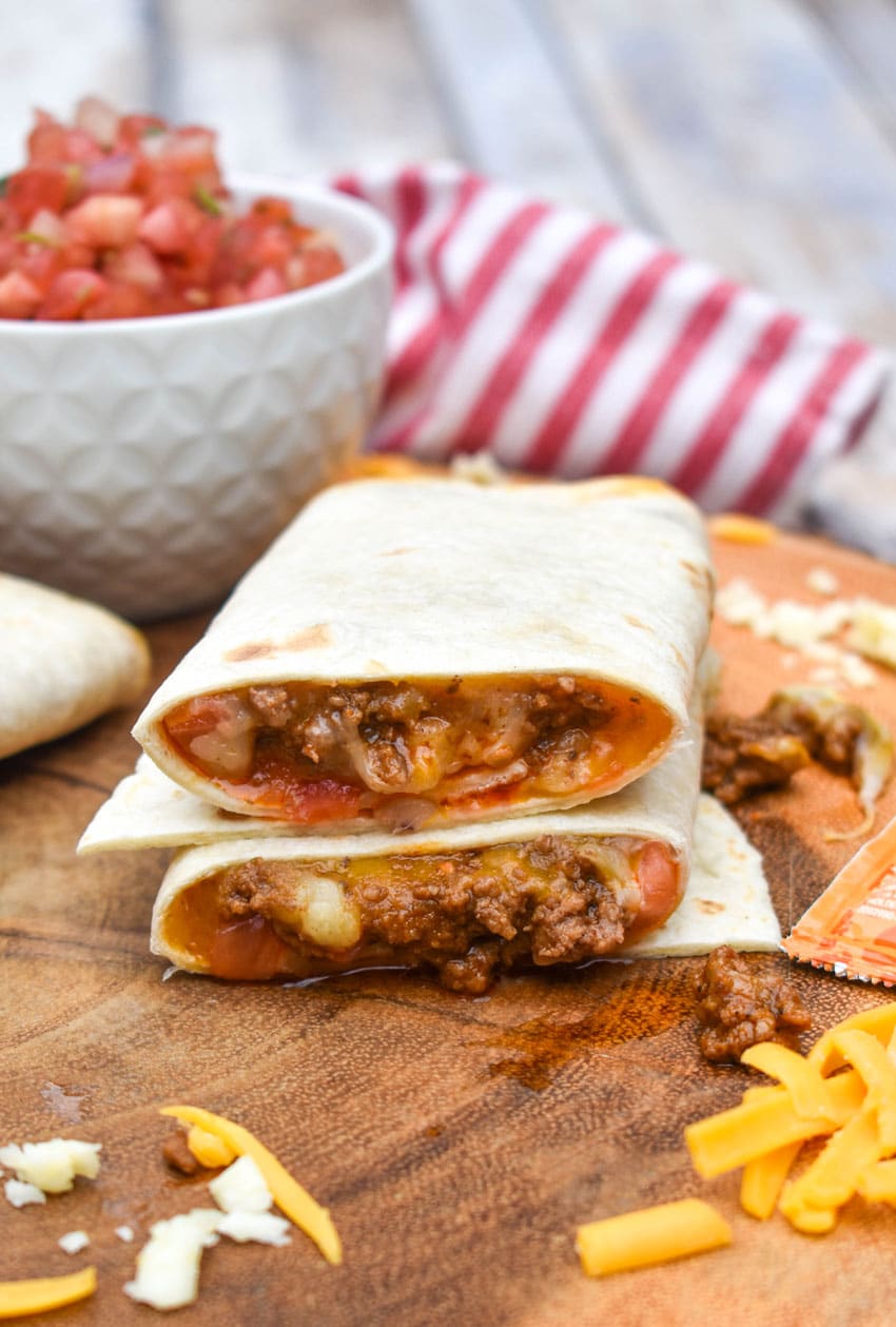 copycat taco bell meximelt halves stacked on a wooden cutting board