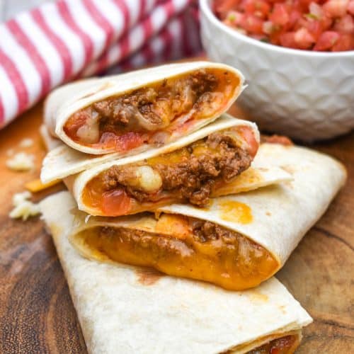 homemade taco bell mexi melts stacked on a wooden cutting board