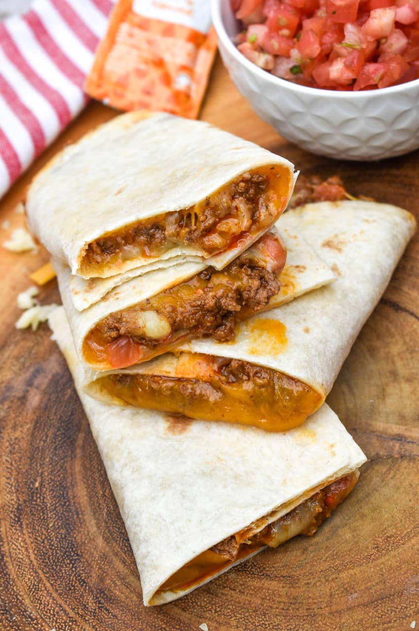 homemade taco bell mexi melts stacked on a wooden cutting board