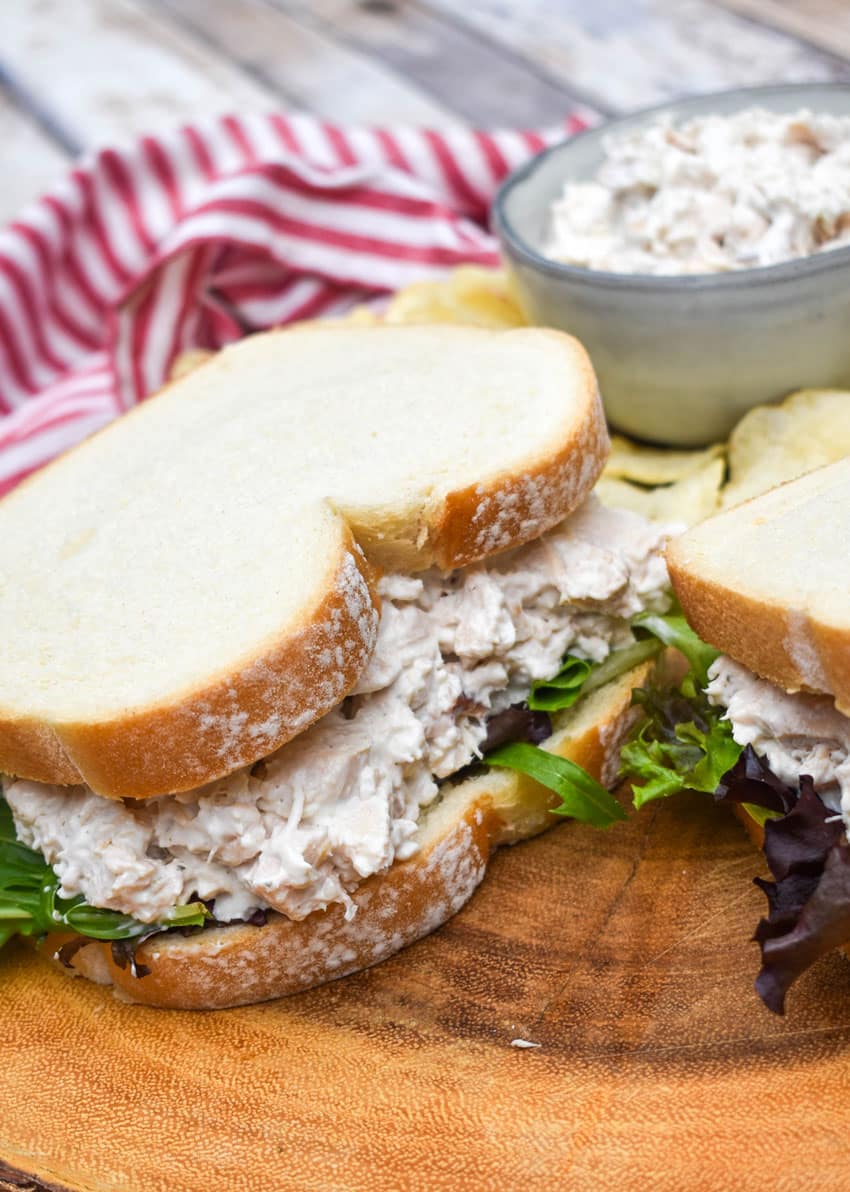 creamy french onion dip chicken salad sandwich on a wooden cutting board