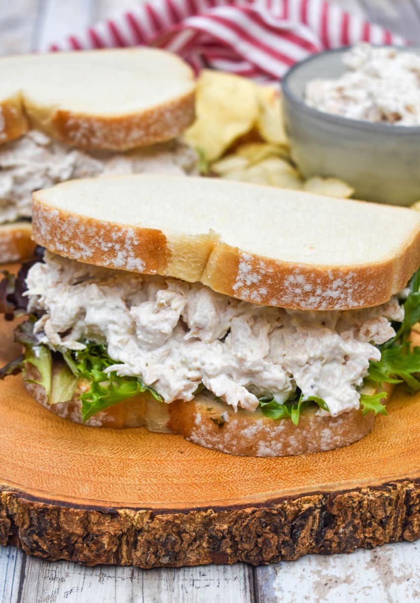 creamy french onion dip chicken salad sandwich on a wooden cutting board