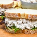 creamy french onion dip chicken salad sandwich on a wooden cutting board
