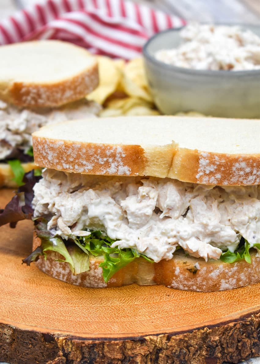 creamy french onion dip chicken salad sandwich on a wooden cutting board