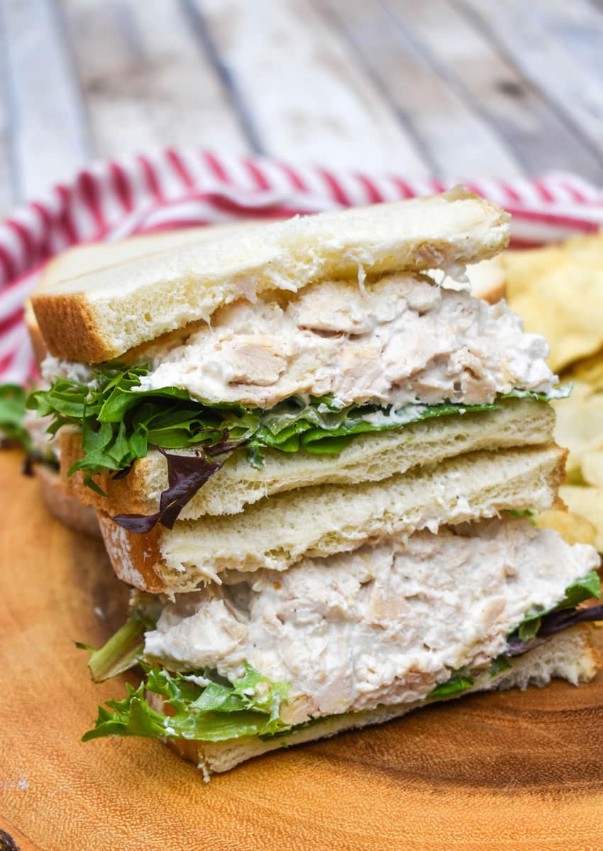 creamy french onion dip chicken salad sandwich on a wooden cutting board