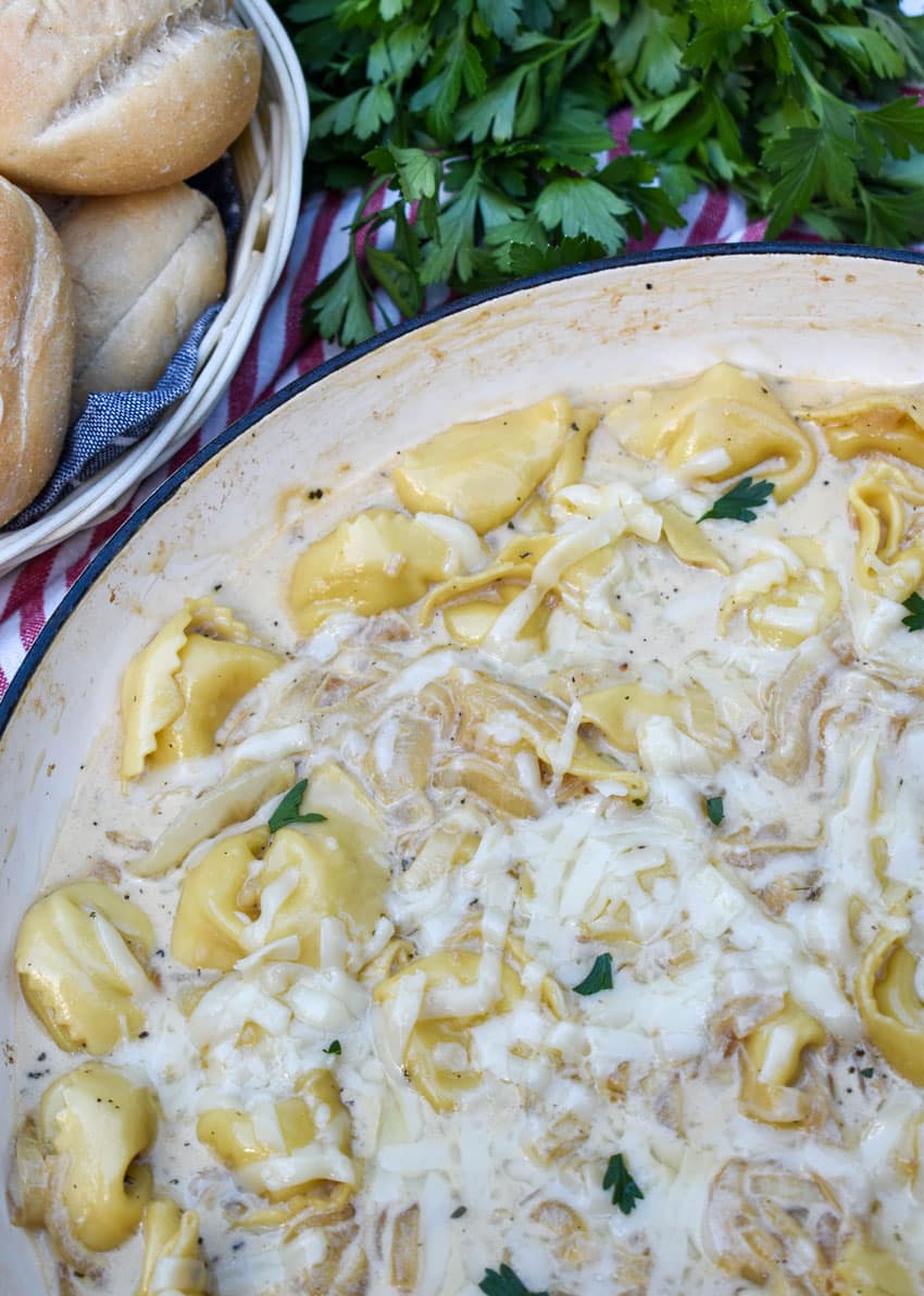 creamy french onion tortellini in a large cast iron skillet