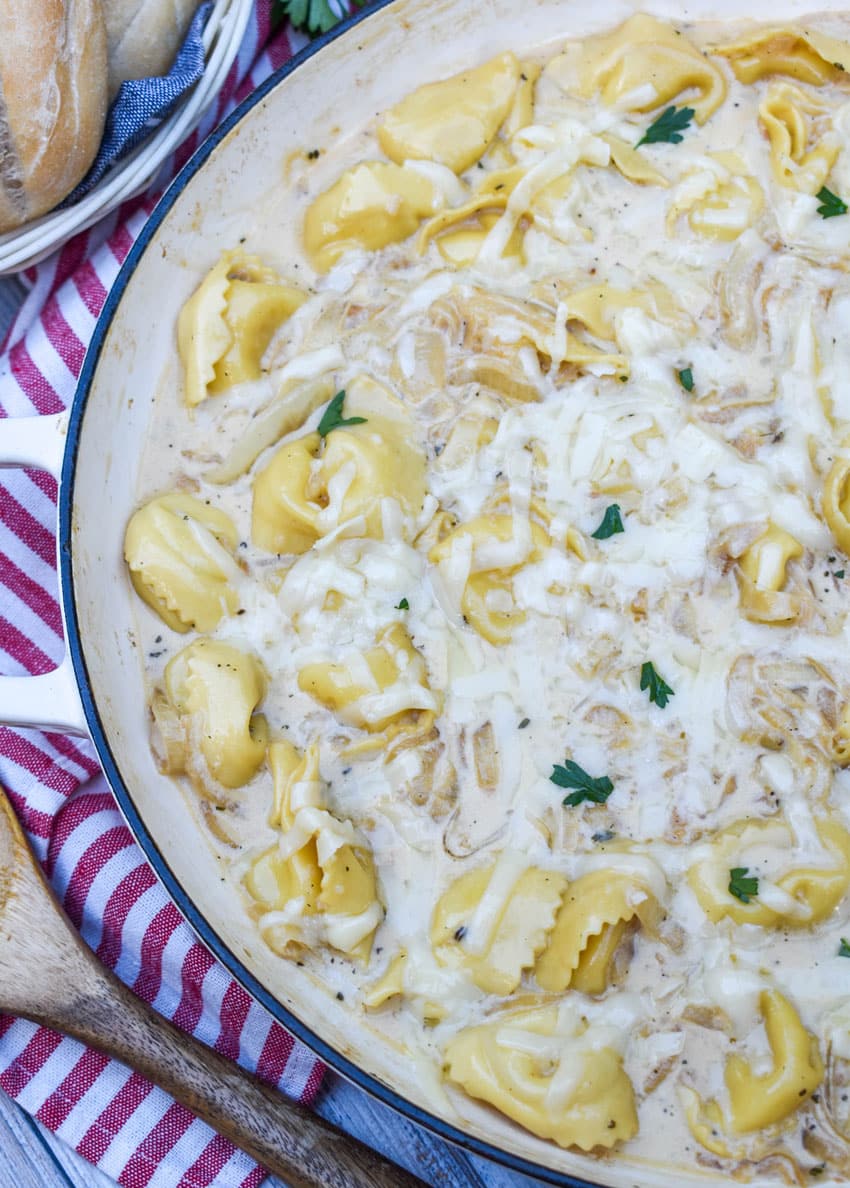creamy french onion tortellini in a large cast iron skillet