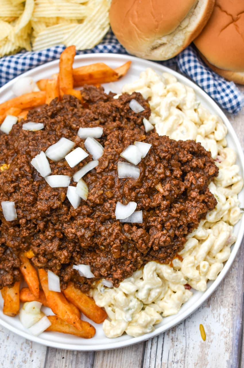 french fries and macaroni salad topped with hot dog chili on a white plate