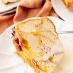 a slice of a breakfast bundt bake on a white plate with a silver fork resting on the side