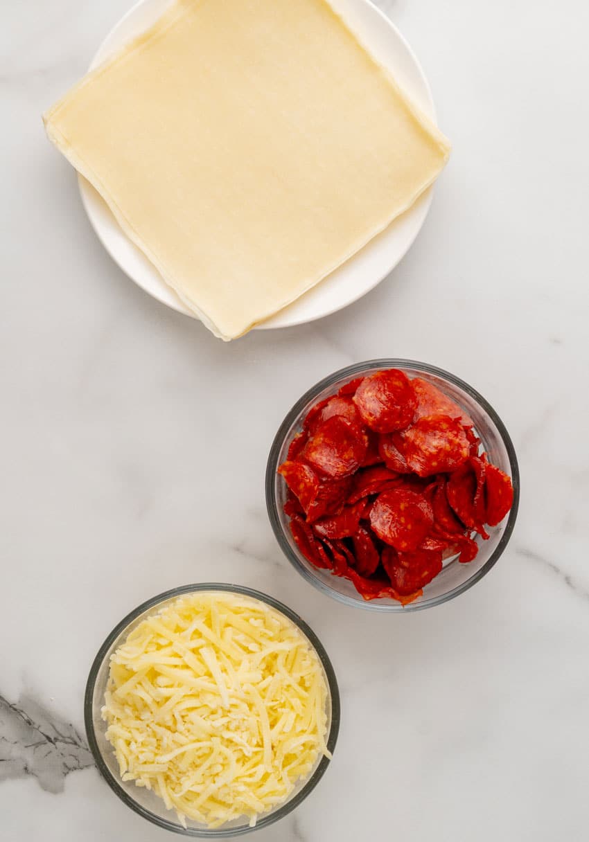 an overhead image showing the measured ingredients needed to make a batch of copycat disney pepperoni spring rolls