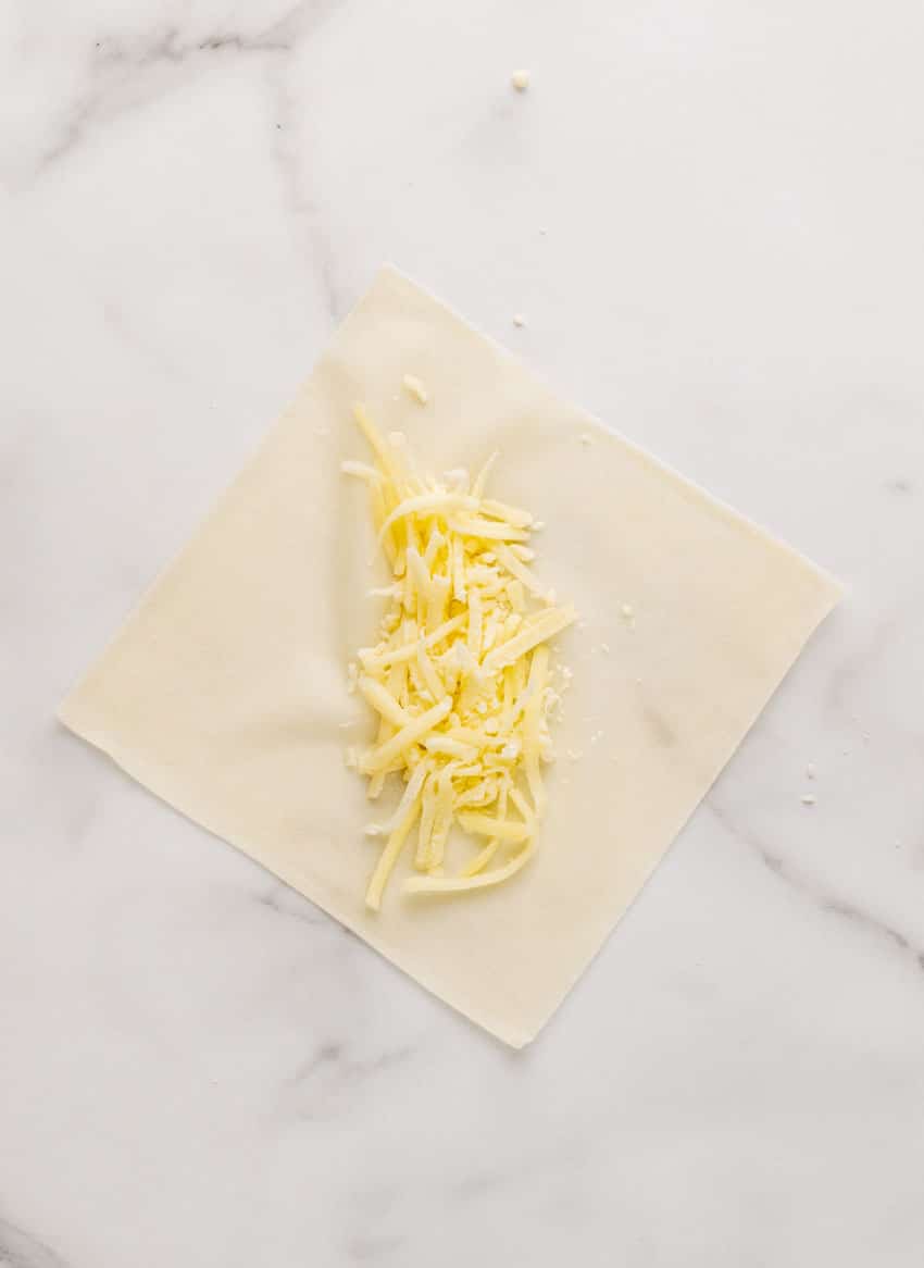shredded mozzarella spread out on a spring roll wrapper