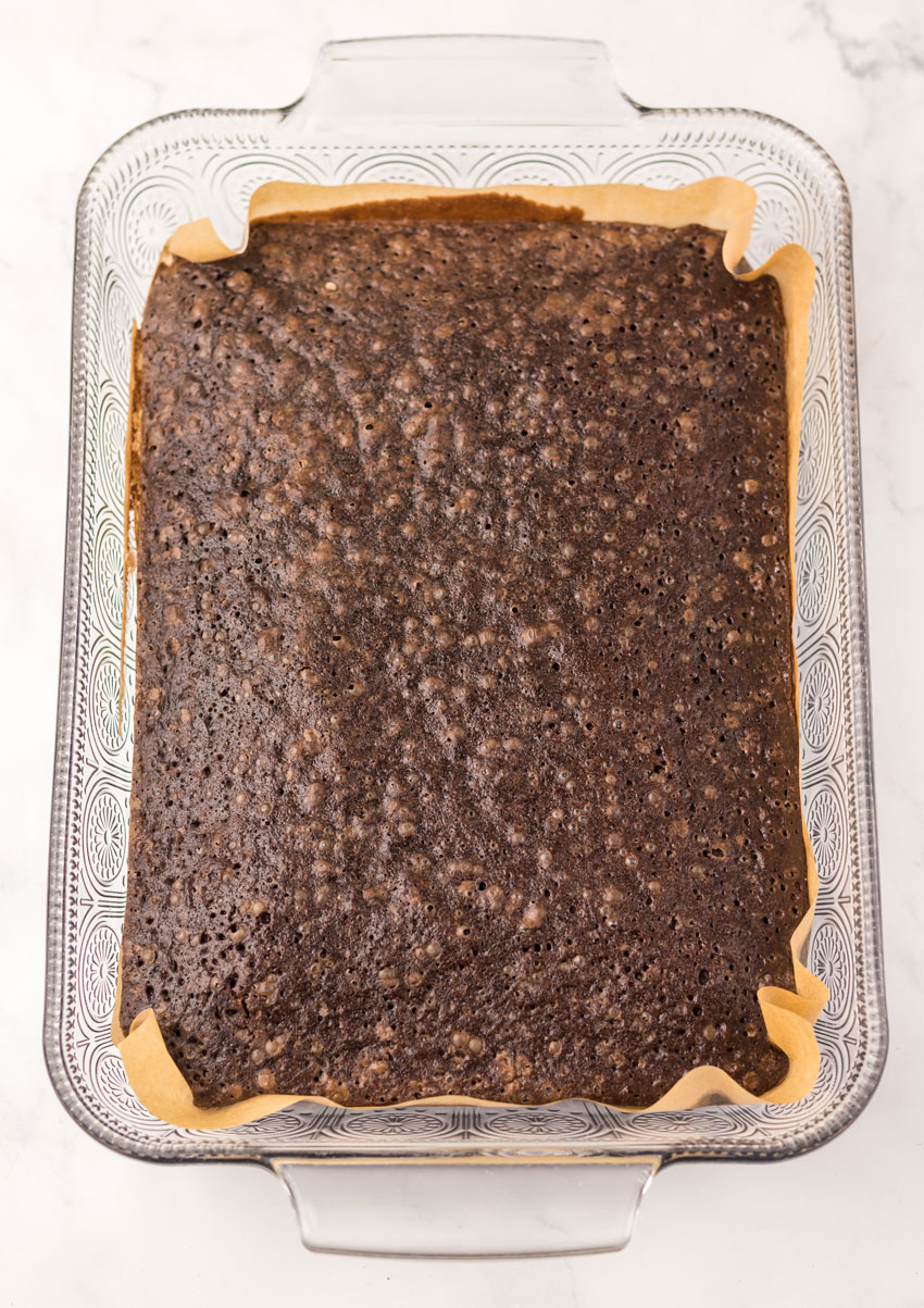 baked dr pepper brownies in a parchment paper lined glass baking dish
