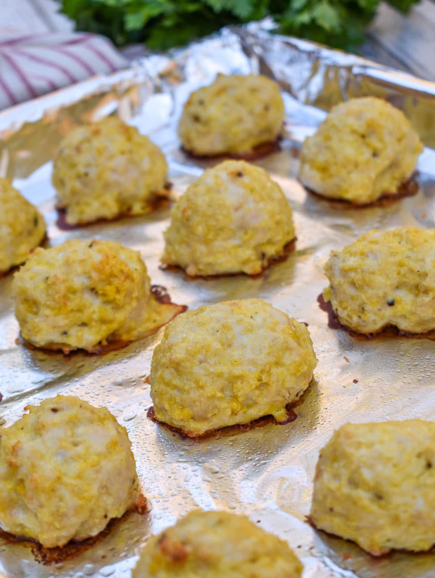 easy baked chicken meatballs on an aluminum foil lined baking sheet