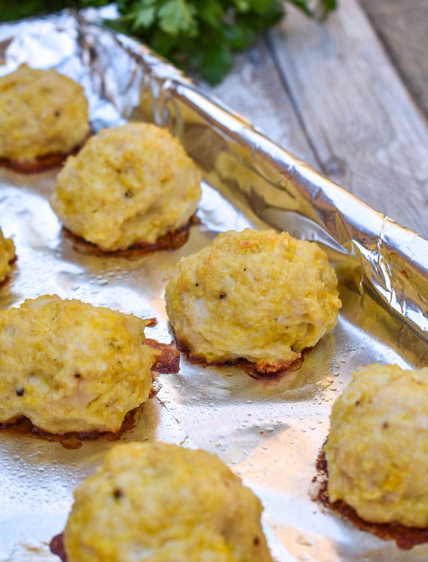 easy baked chicken meatballs on an aluminum foil lined baking sheet