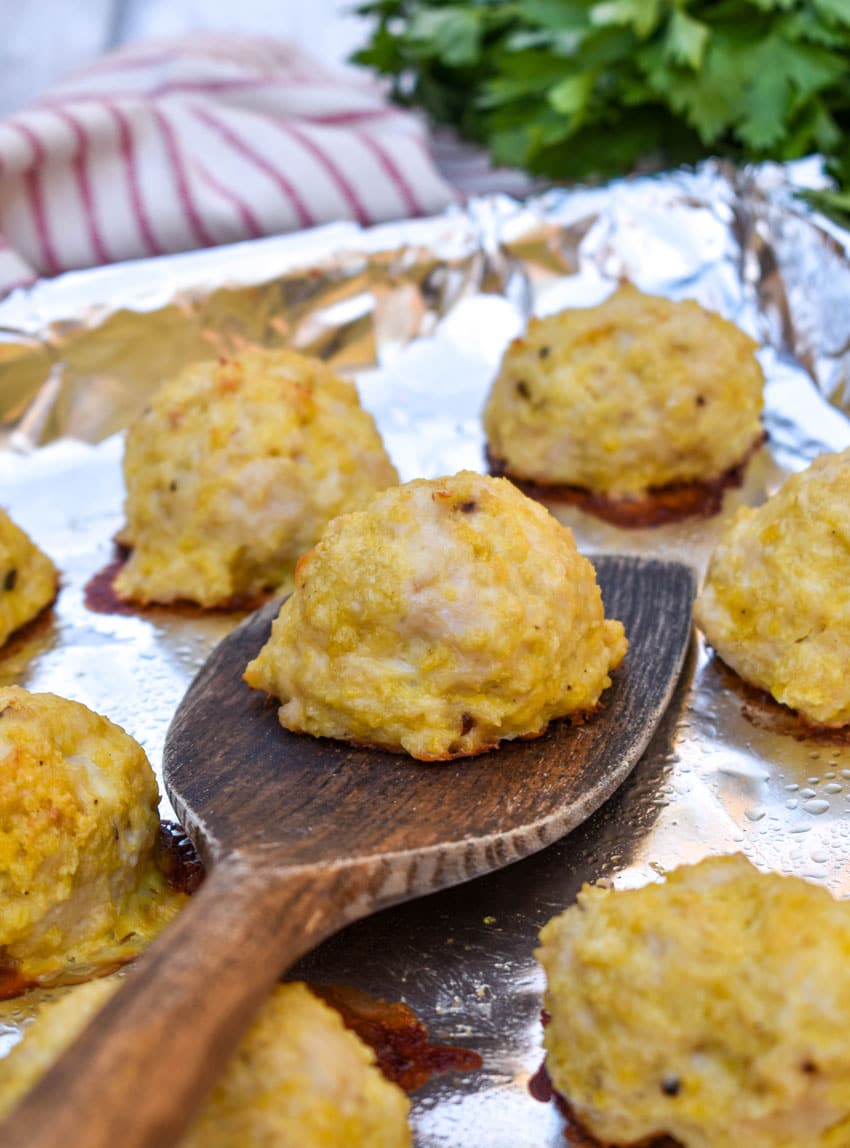 easy baked chicken meatballs on an aluminum foil lined baking sheet