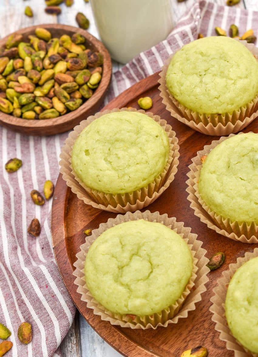 pistachio pudding muffins on a wooden cake stand