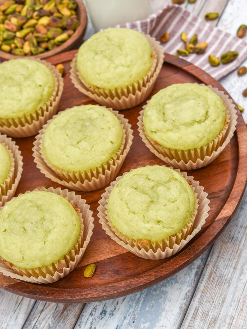 pistachio pudding muffins on a wooden cake stand