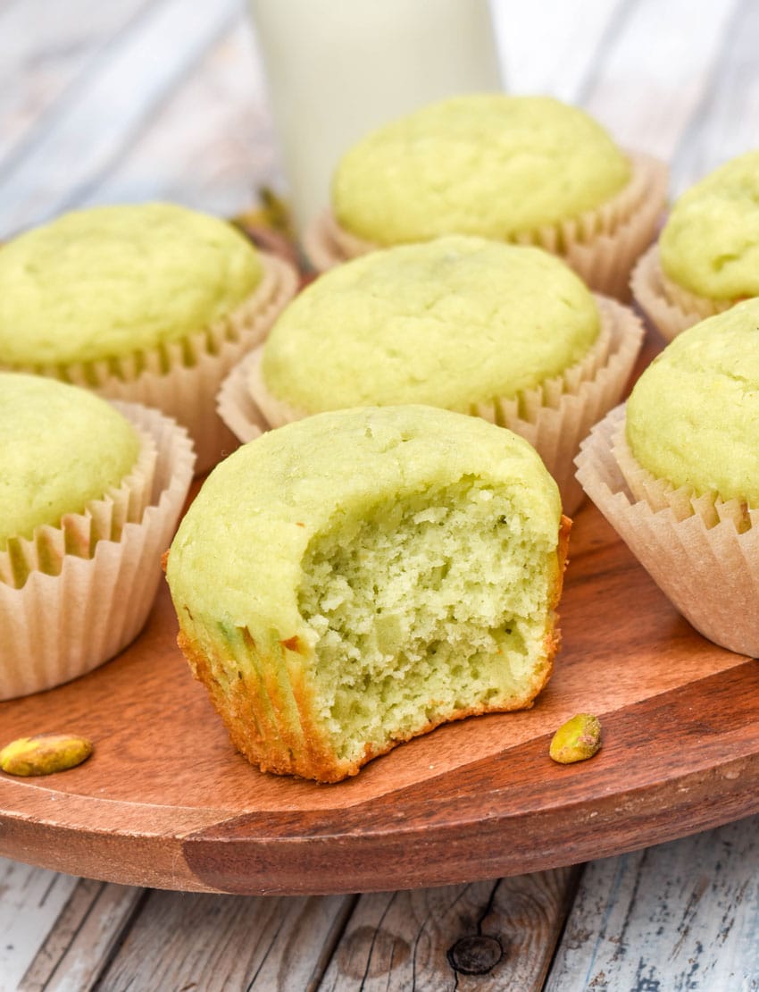 pistachio pudding muffins on a wooden cake stand