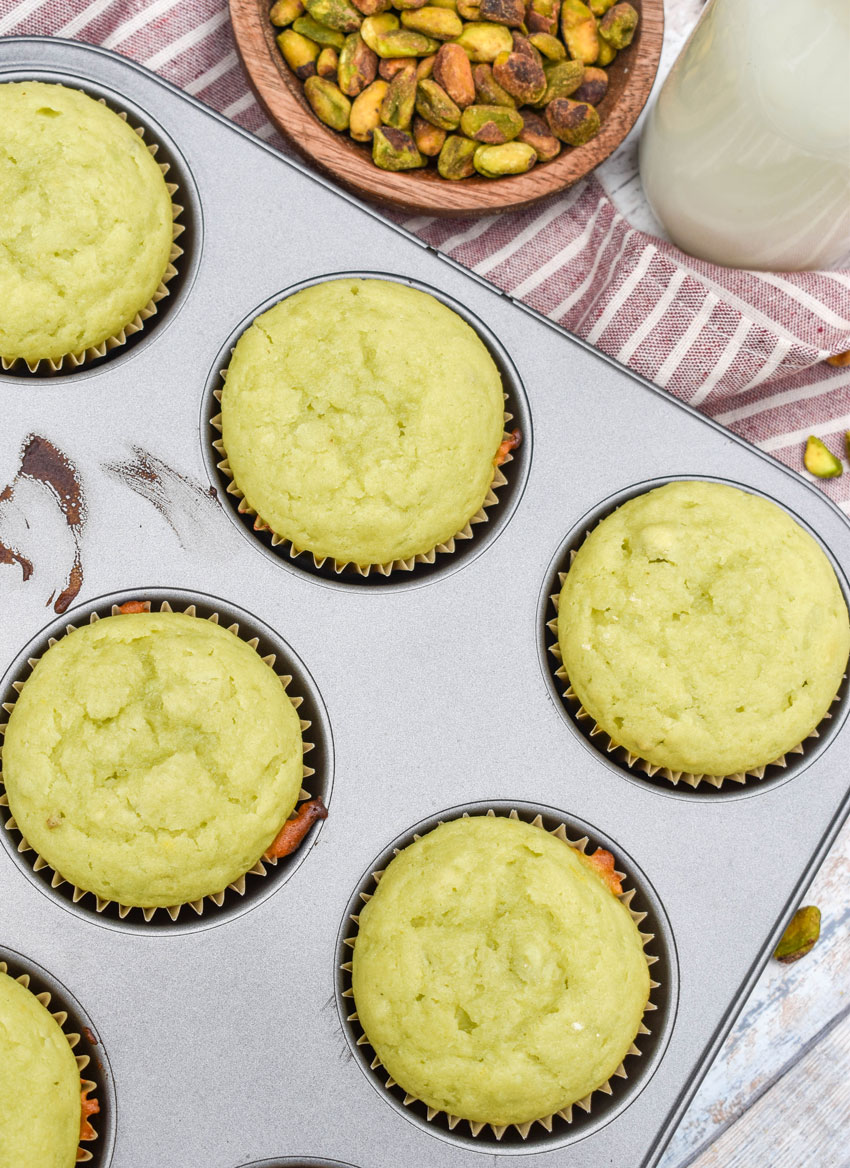 pistachio pudding muffins in a metal muffin tin pan