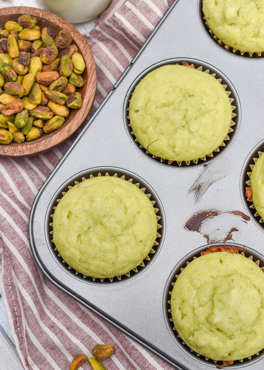 pistachio pudding muffins in a metal muffin tin pan