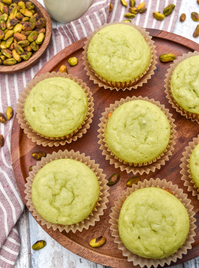 pistachio pudding muffins on a wooden cake stand