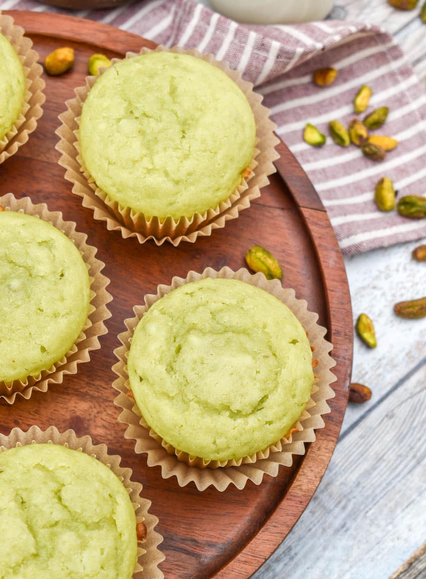 pistachio pudding muffins on a wooden cake stand