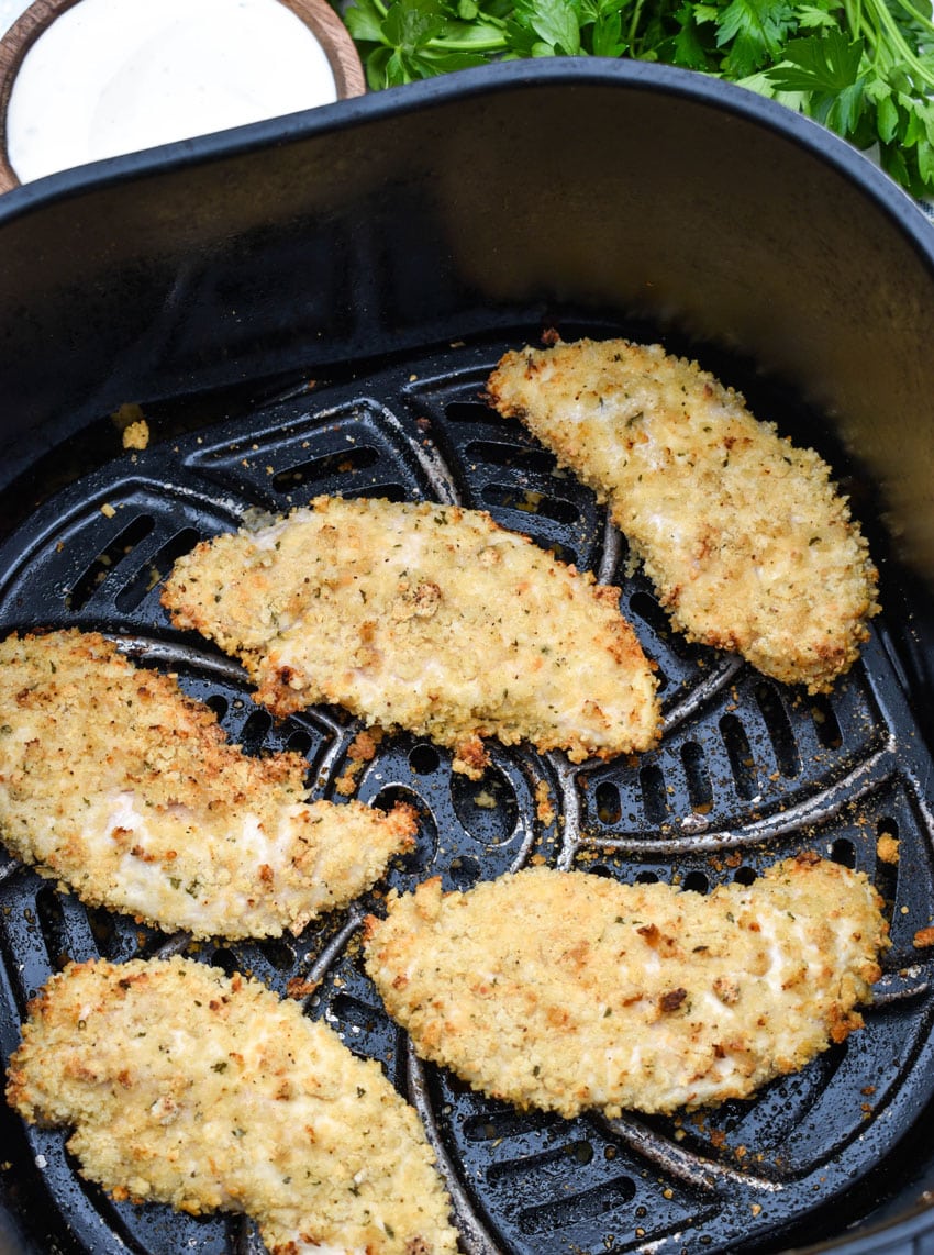 ranch seasoned homemade chicken tenders in the basket of an air fryer