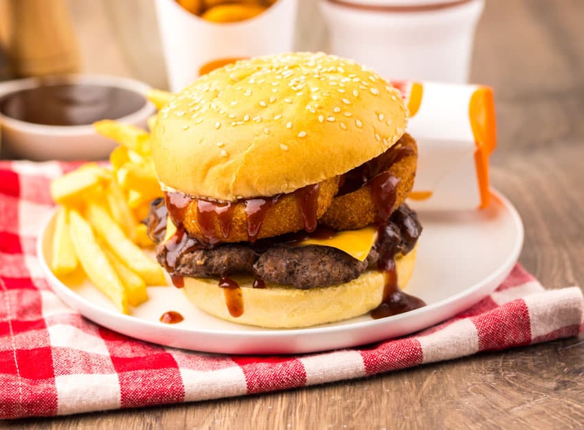 copycat burger king rodeo burger on a small white plate with french fries on the side