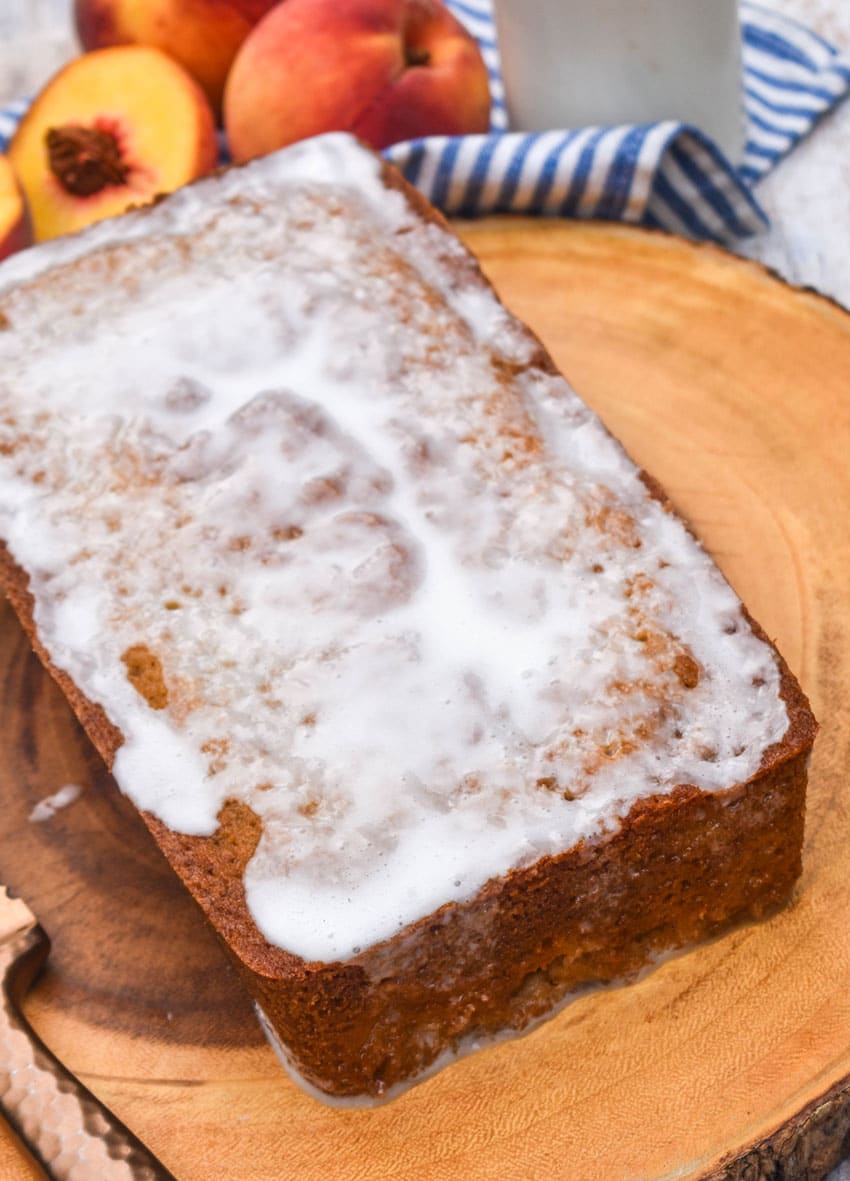 southern glazed peach bread on a wooden cutting board