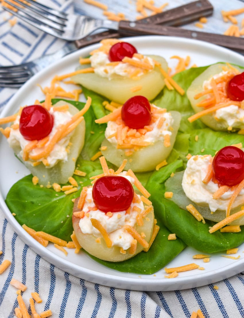 southern pear salad bites arranged over butter lettuce leaves on a white plate