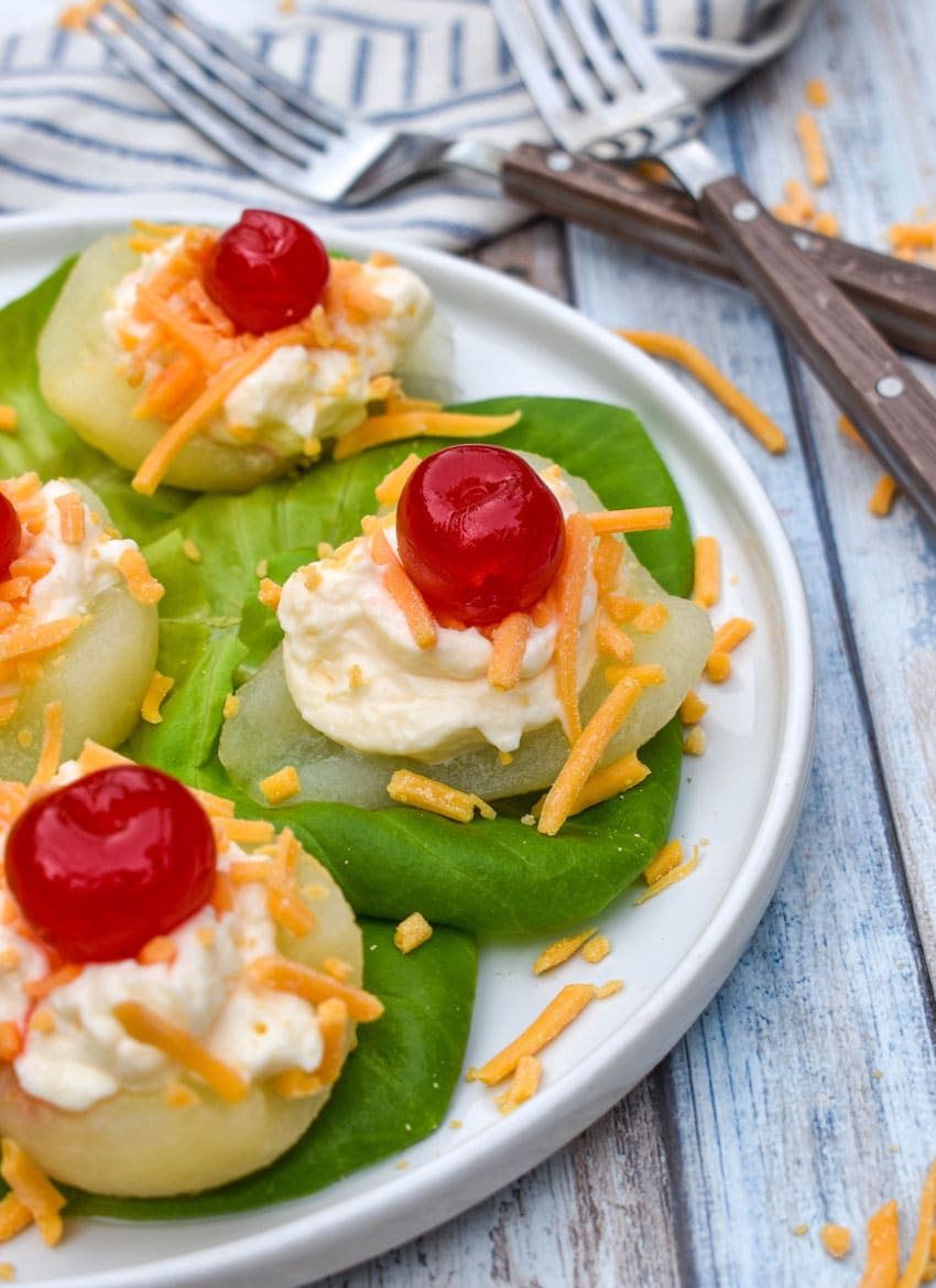 southern pear salad bites arranged over butter lettuce leaves on a white plate