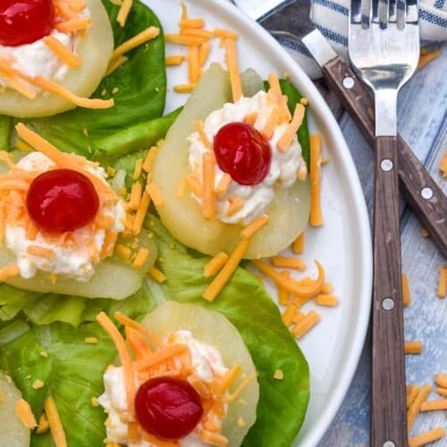 southern pear salad bites arranged over butter lettuce leaves on a white plate