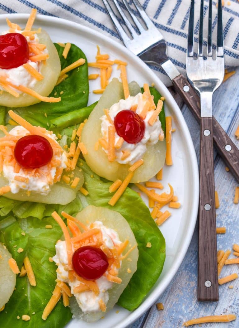 southern pear salad bites arranged over butter lettuce leaves on a white plate