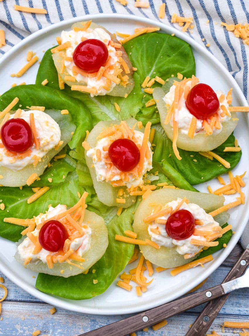 southern pear salad bites arranged over butter lettuce leaves on a white plate