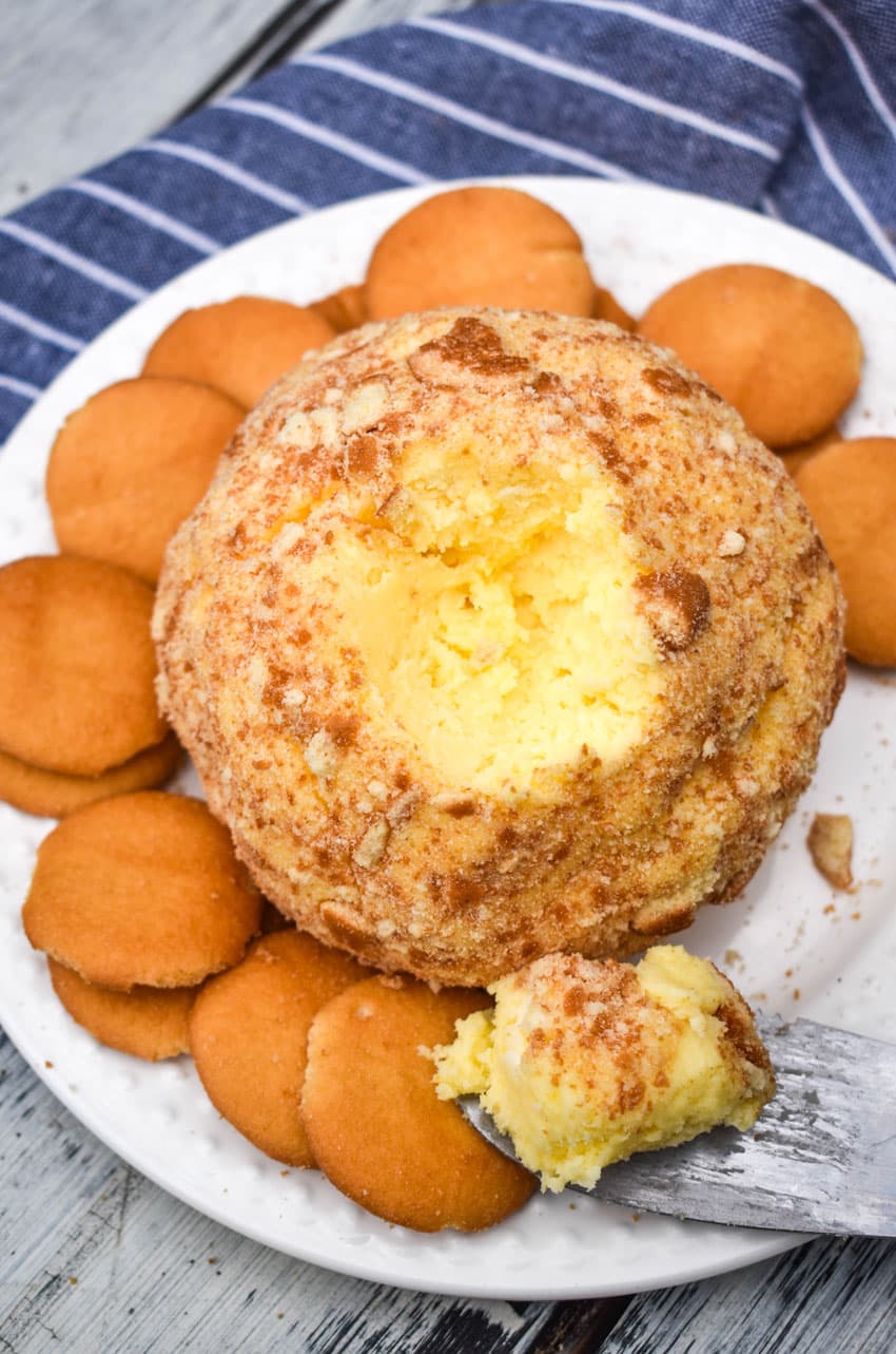 a banana pudding cheese ball surrounded by nilla wafers on a small white plate
