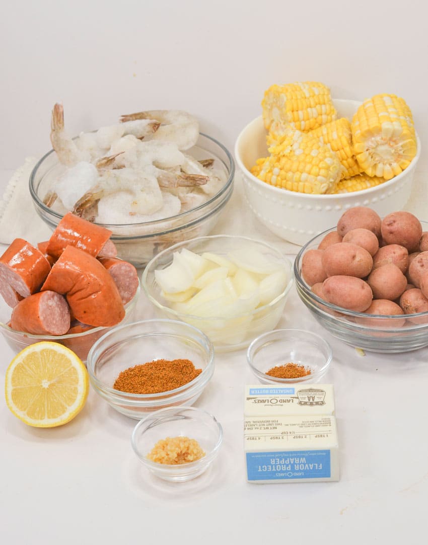 an overhead image showing the measured ingredients needed to make a shrimp boil in the crockpot