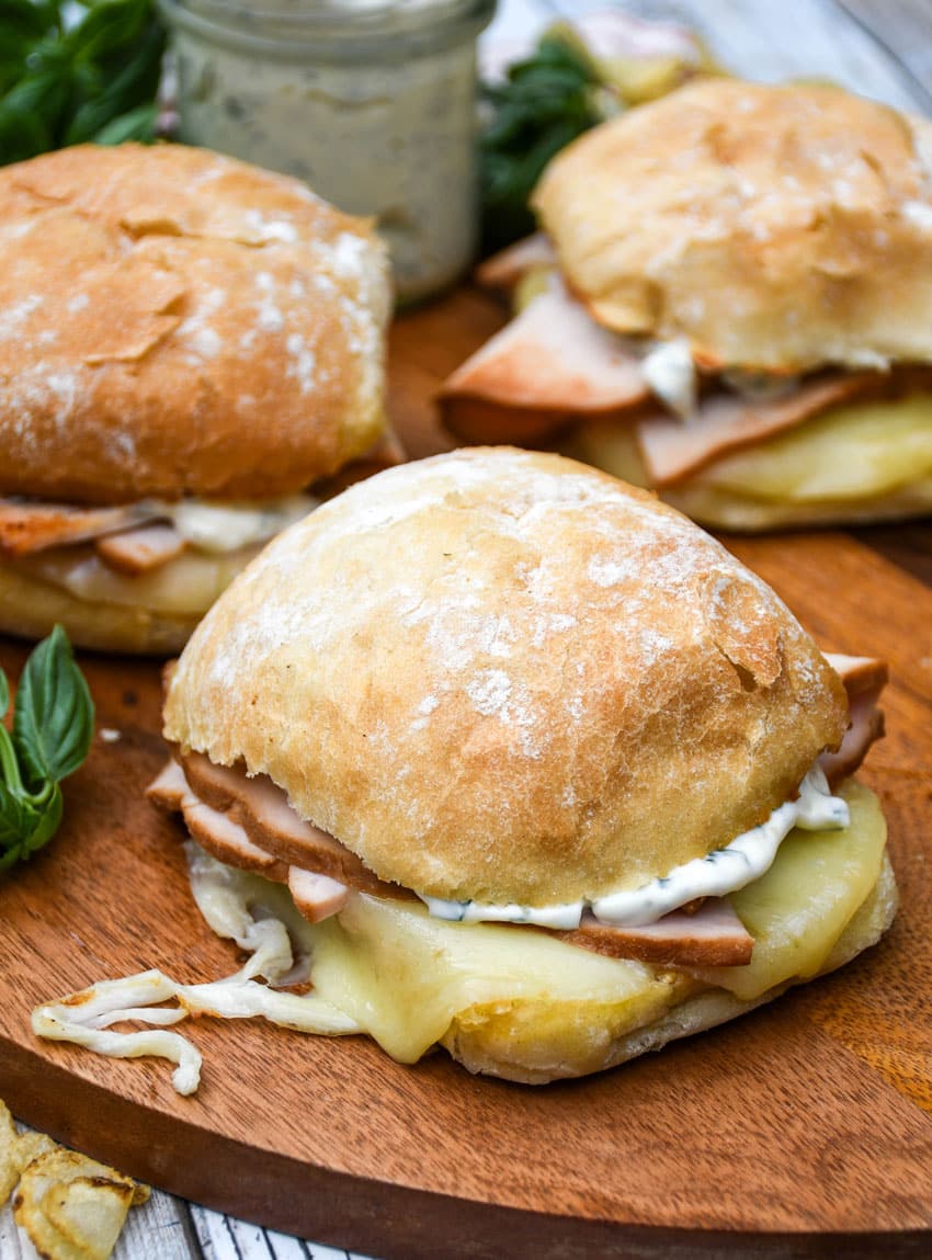 copycat costco hot turkey provolone sandwiches on a wooden cutting board