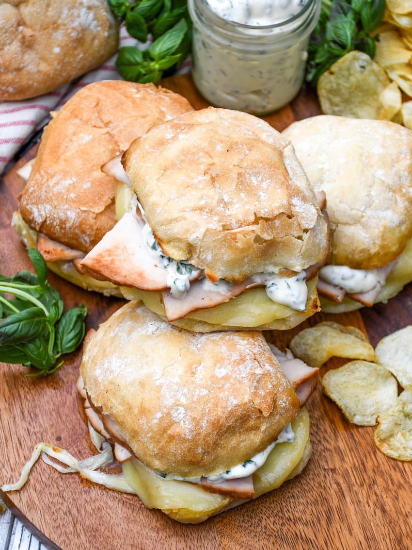 copycat costco hot turkey provolone sandwiches on a wooden cutting board