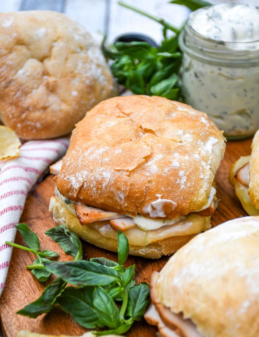 copycat costco hot turkey provolone sandwiches on a wooden cutting board