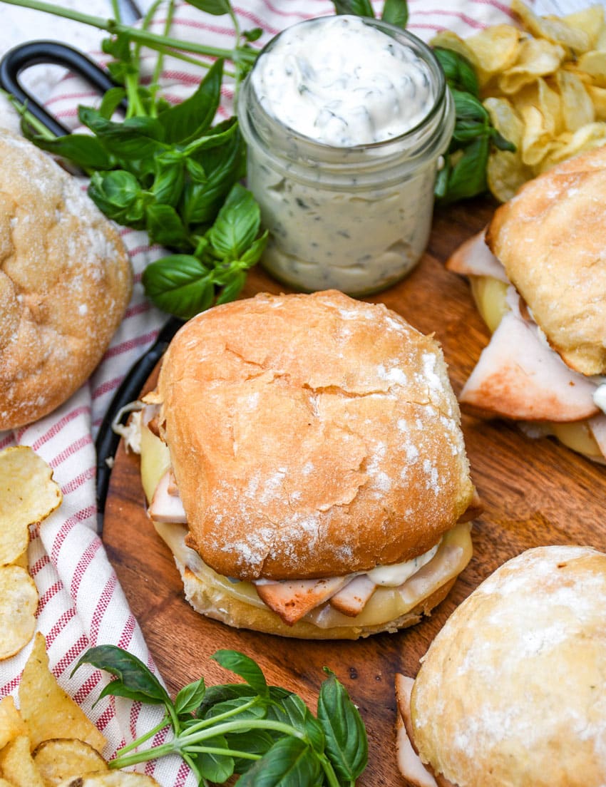 copycat costco hot turkey provolone sandwiches on a wooden cutting board