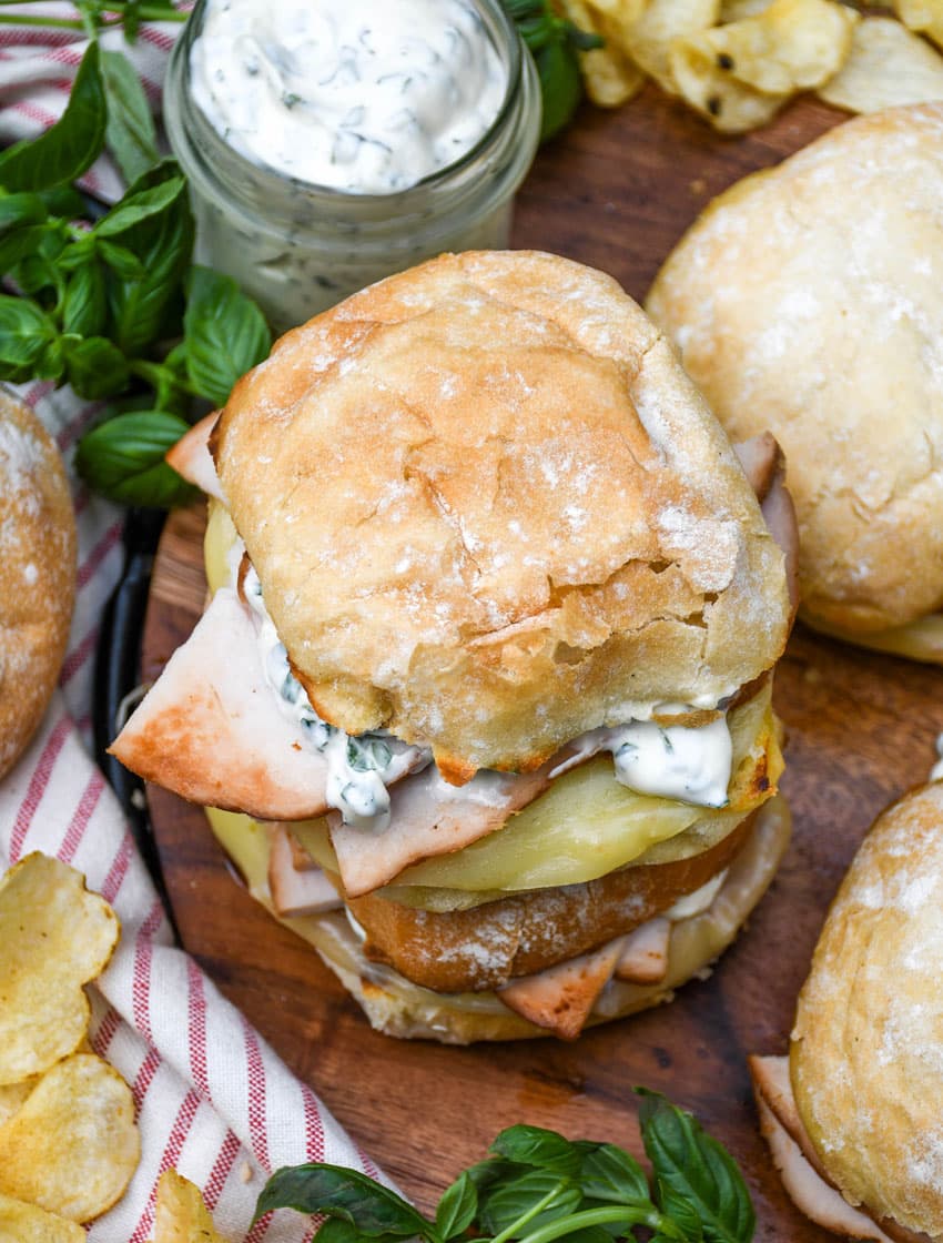copycat costco hot turkey provolone sandwiches on a wooden cutting board