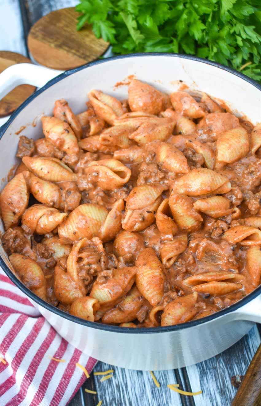 creamy beef and shells pasta in a large cast iron pot
