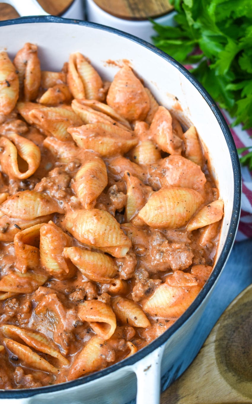 creamy beef and shells pasta in a large cast iron pot