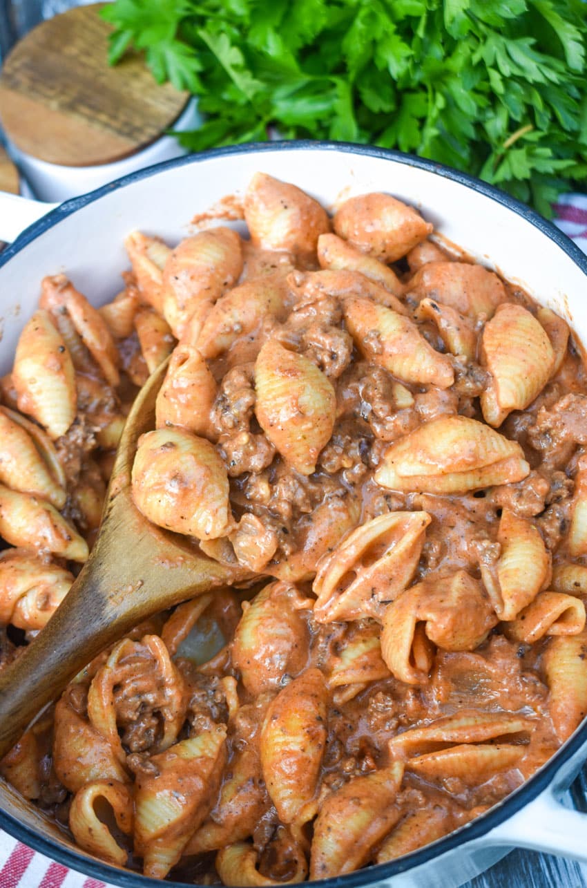 creamy beef and shells pasta in a large cast iron pot