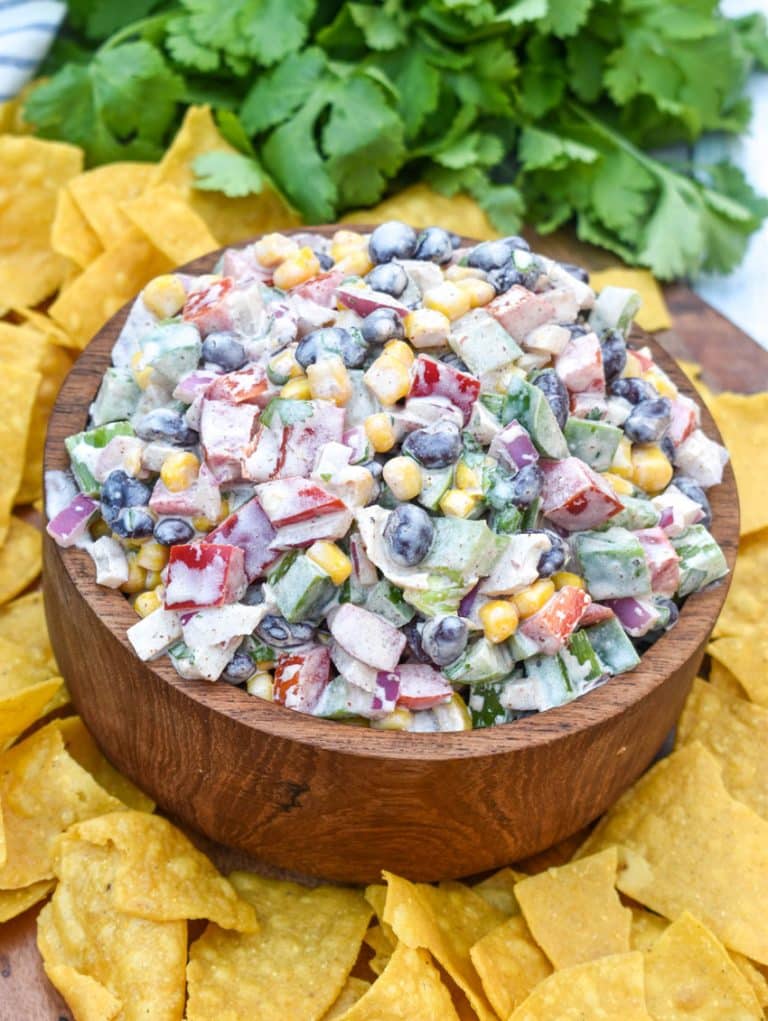 creamy black bean salsa in a wooden bowl surrounded by homemade tortilla chips