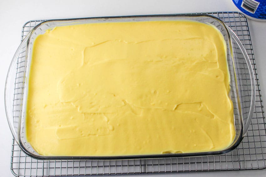 a layer of vanilla pudding spread over a cooling cake